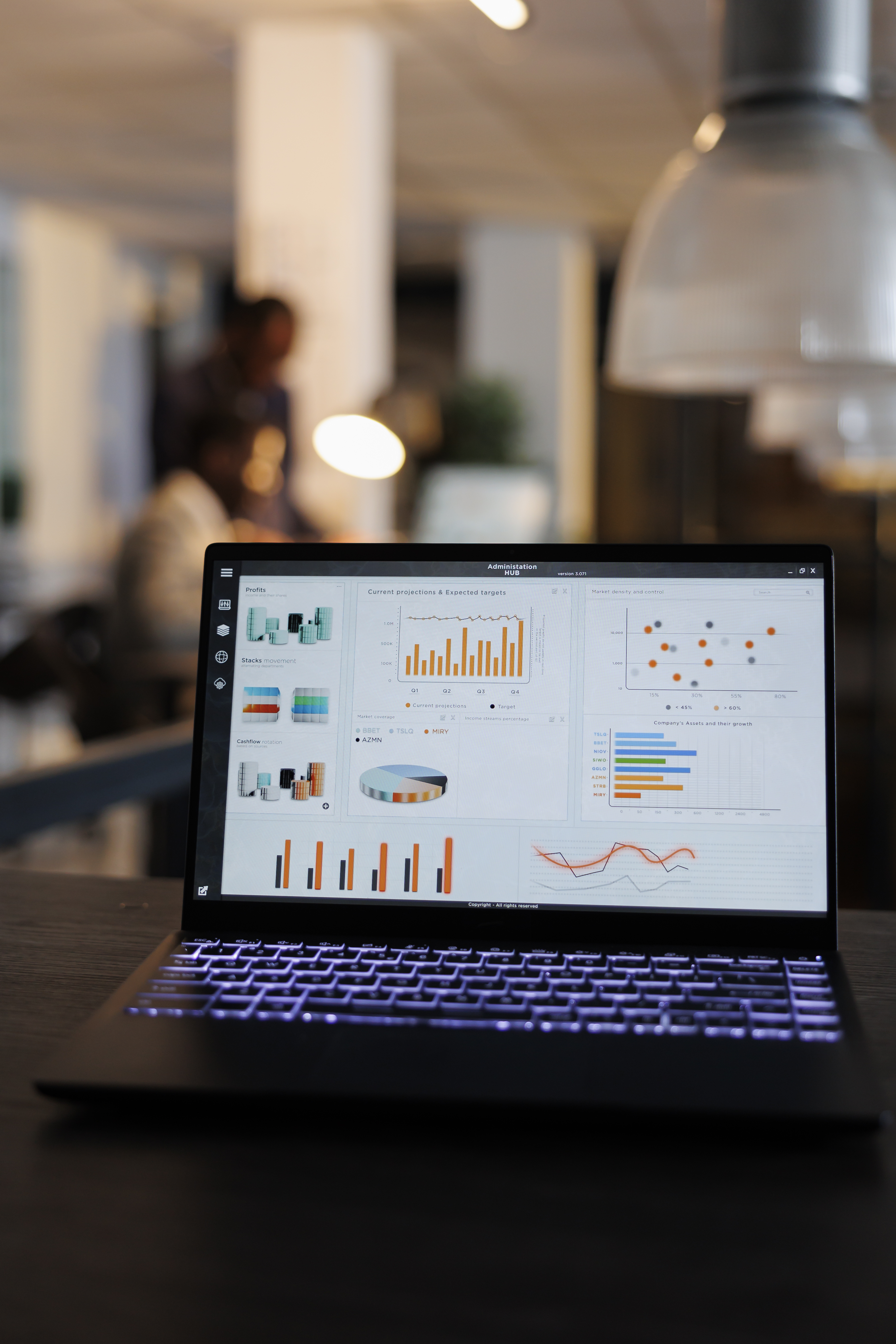 laptop-computer-with-marketing-statistics-graphs-screen-standing-table-startup-office-coworkers-discussing-company-strategy-background-employees-working-overtime-startup-office.jpg